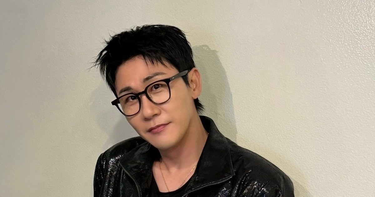 영탁이 벽에 기대어 안경을 쓰고 부드럽게 미소 짓는 모습