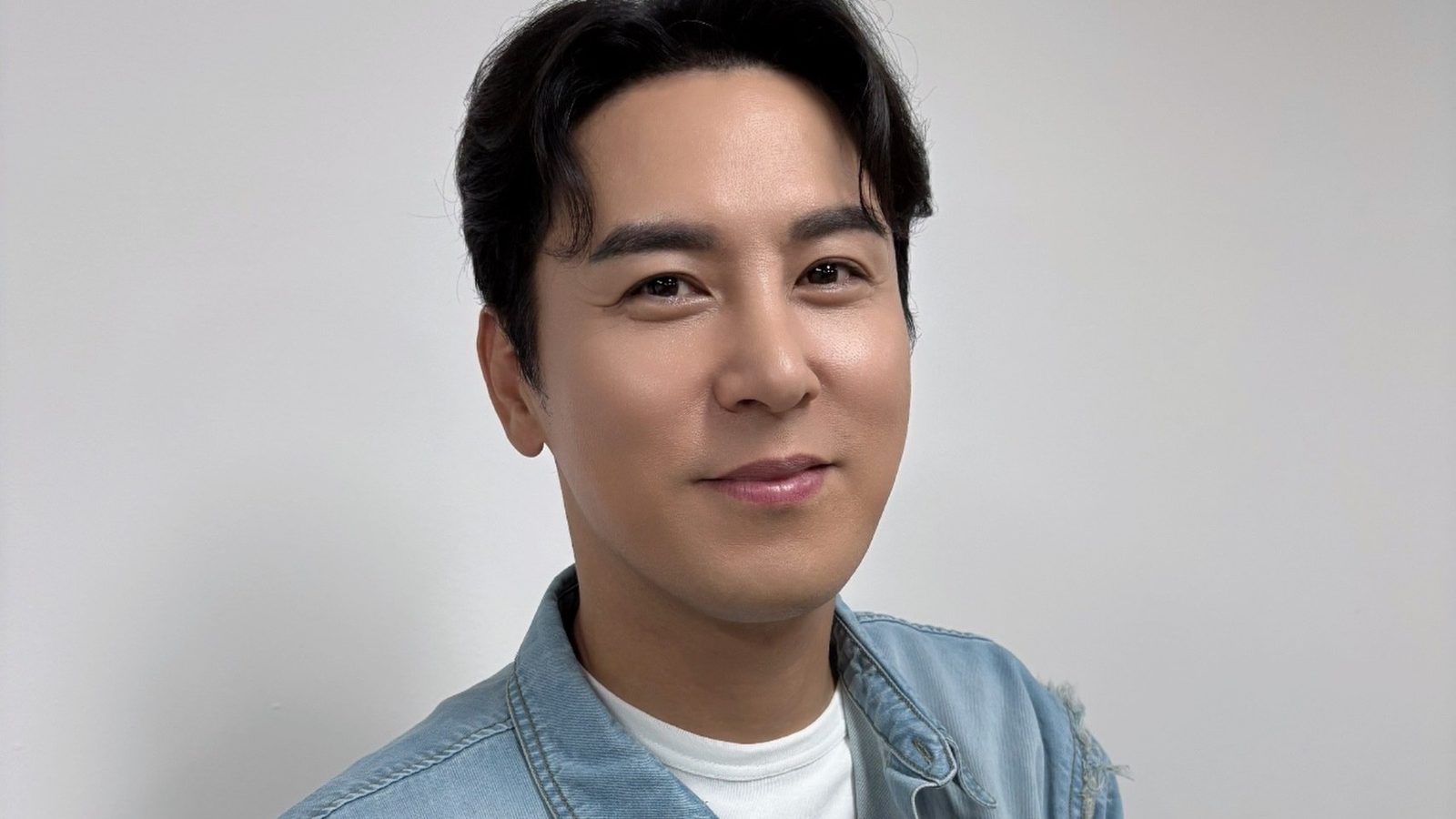 생일 케이크를 들고 브이 포즈로 웃는 장민호의 상반신 사진