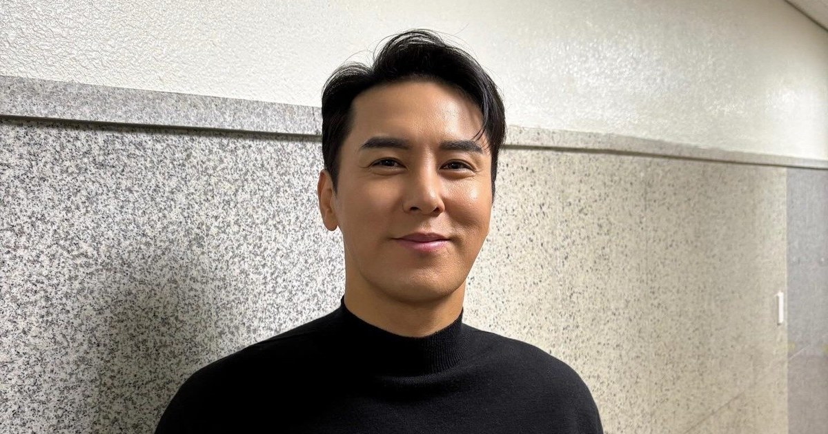 장민호가 콘서트 현장 대기실에서 검은색 스웨터를 입고 웃는 모습
