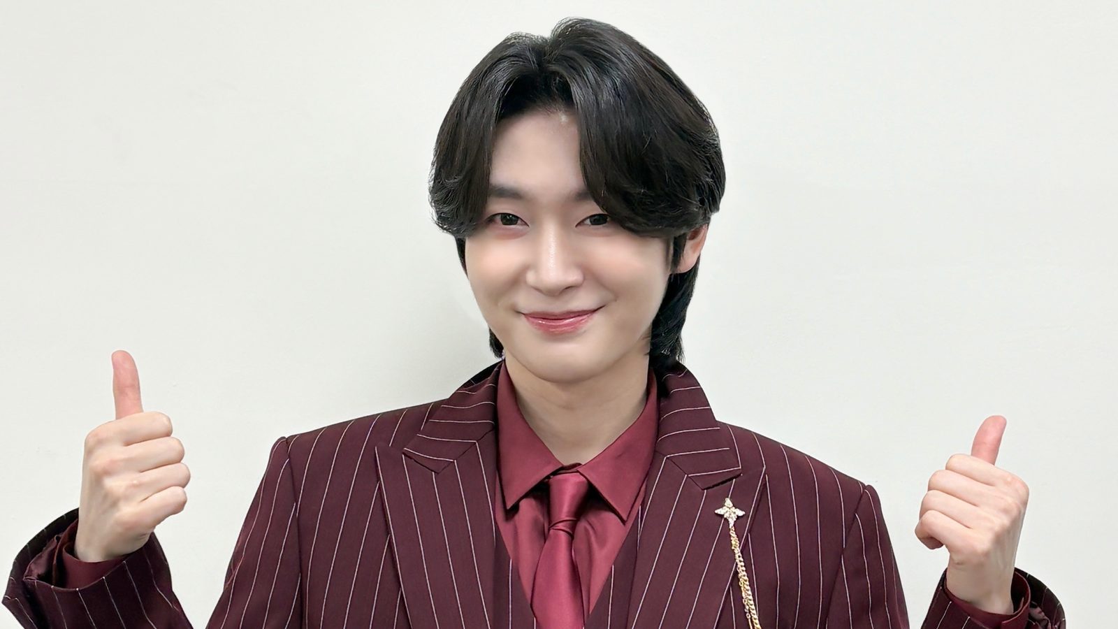 버건디 핀스트라이프 수트 차림으로 두 엄지를 들어 보이는 김용빈 자료사진