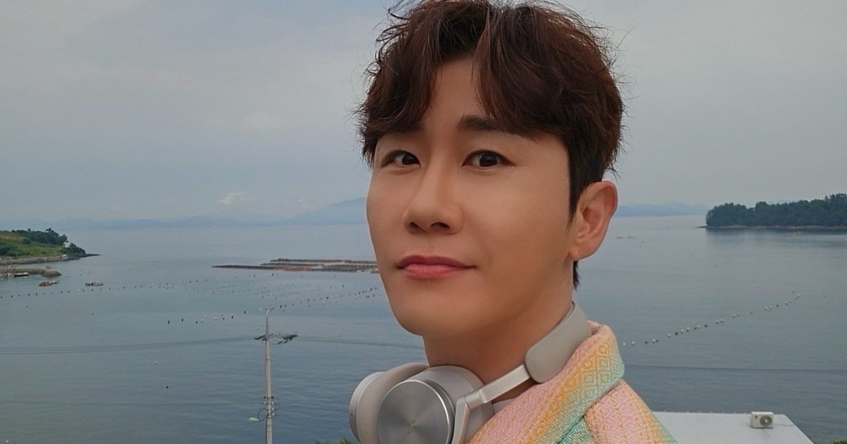 영탁이 목에 헤드폰을 걸고 바닷가를 배경으로 서 있는 모습