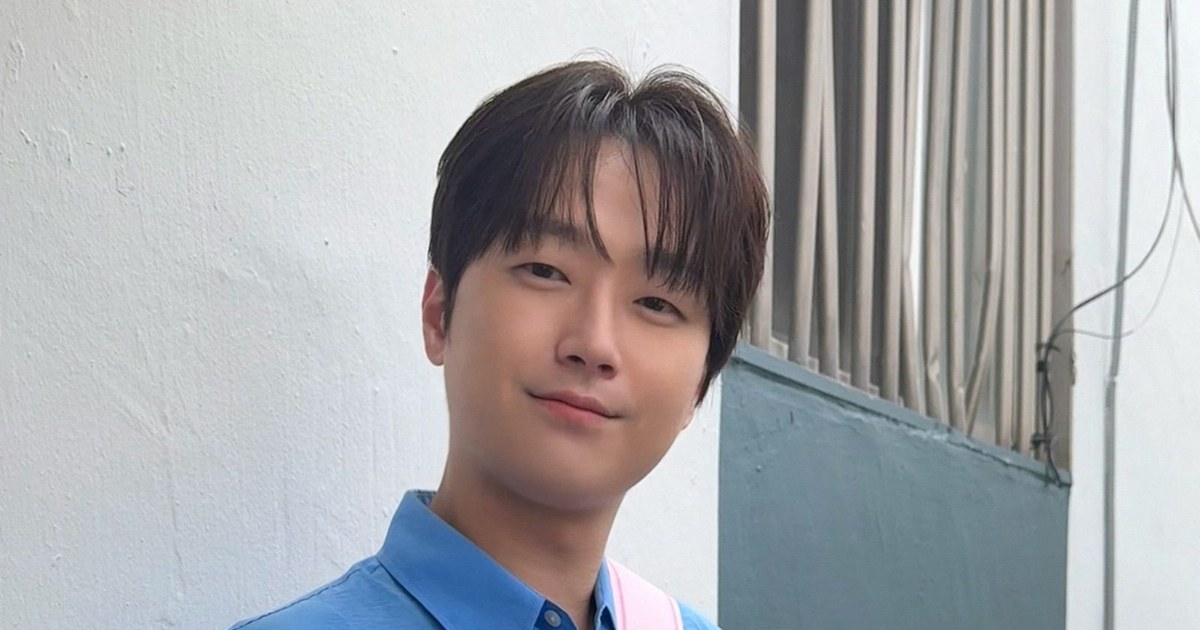 이찬원이 파란 셔츠를 입고 흰 벽 앞에서 미소 짓는 모습