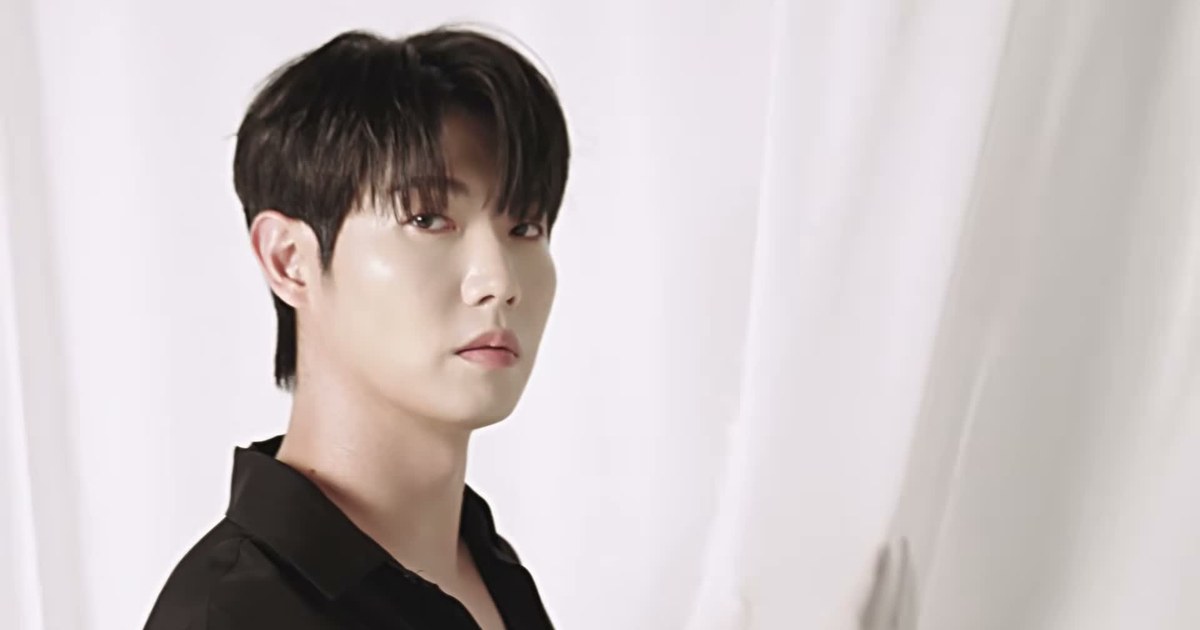흰 커튼 앞에서 검은 셔츠를 입고 카메라를 바라보는 손태진