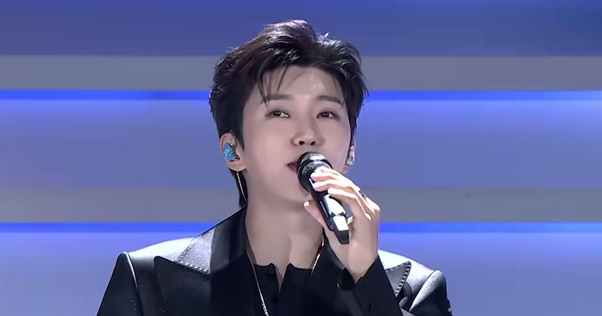 임영웅이 검은 재킷 차림으로 마이크를 들고 노래하는 모습, 임영웅 공식 유튜브 'Baila' 라이브 클립 장면