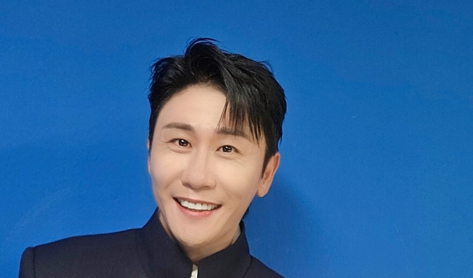 영탁이 파란 배경 앞에서 활짝 웃는 모습