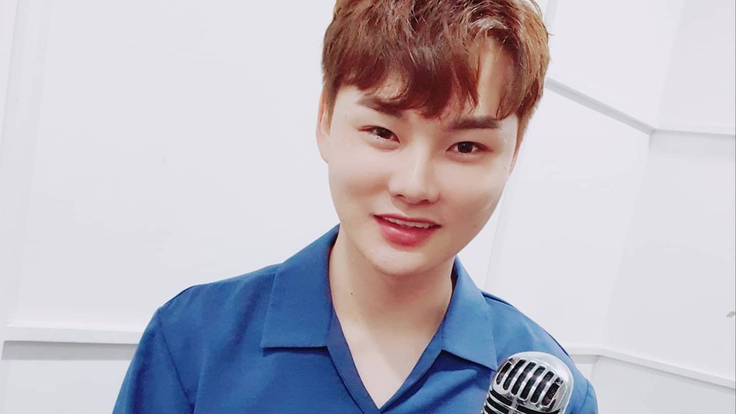 파란 셔츠 차림으로 빈티지 마이크를 들고 환하게 웃는 박서진