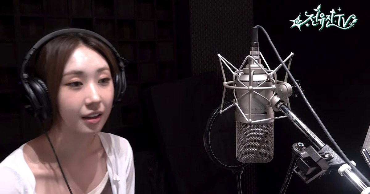 녹음실 마이크 앞에서 헤드폰을 쓰고 말하는 전유진