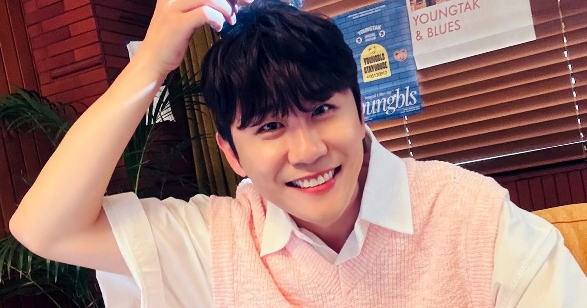 분홍색 니트 조끼 차림으로 한 손을 머리에 얹고 활짝 웃는 영탁