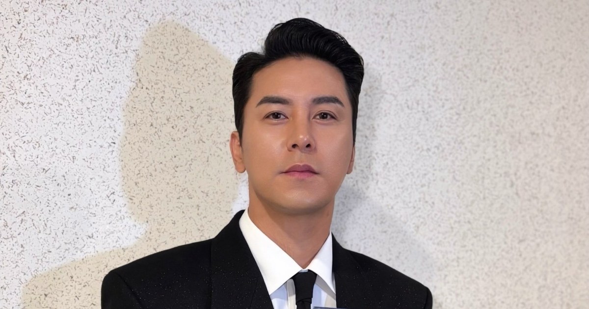 검은 정장에 넥타이를 매고 정면을 바라보는 장민호