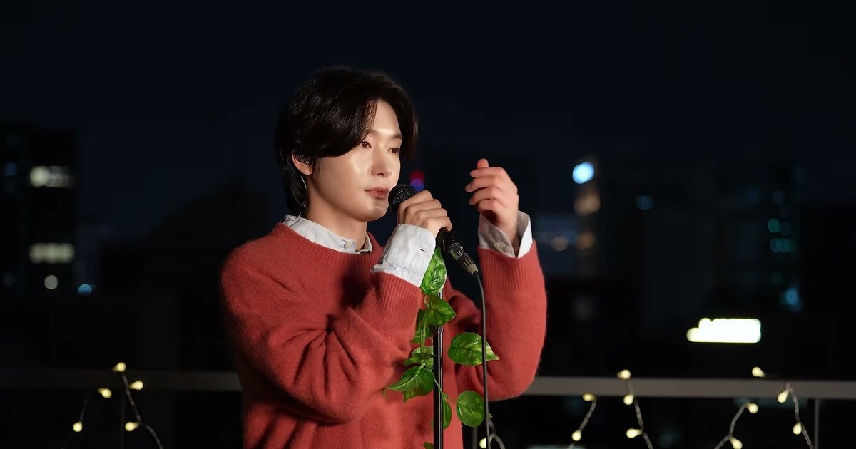 밤 옥상 무대에서 붉은 스웨터 차림의 김용빈이 마이크를 잡고 노래하는 모습