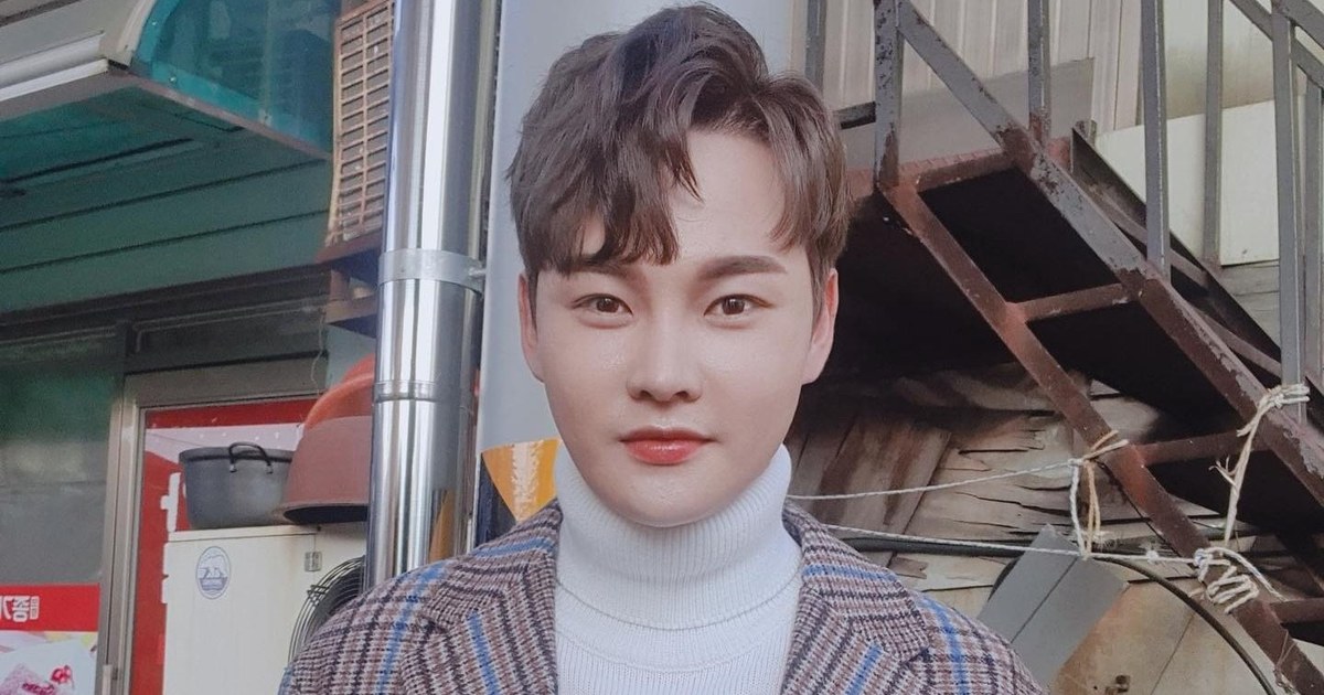 흰 터틀넥에 체크무늬 코트를 입고 정면을 바라보는 박서진