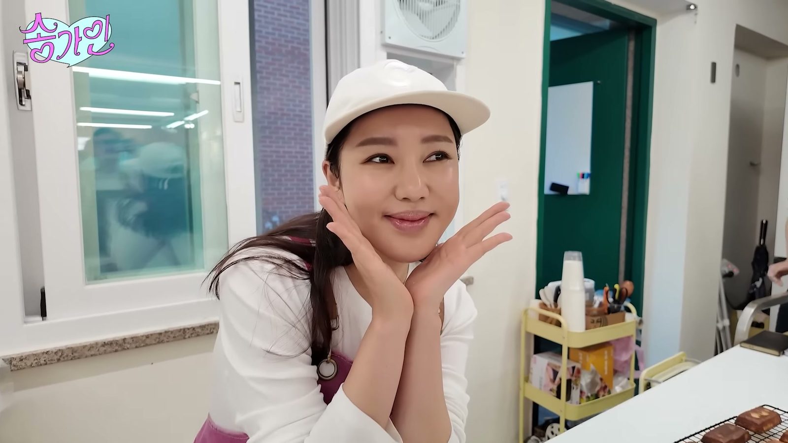 흰 모자를 쓴 송가인이 두 손을 볼에 대고 웃는 모습