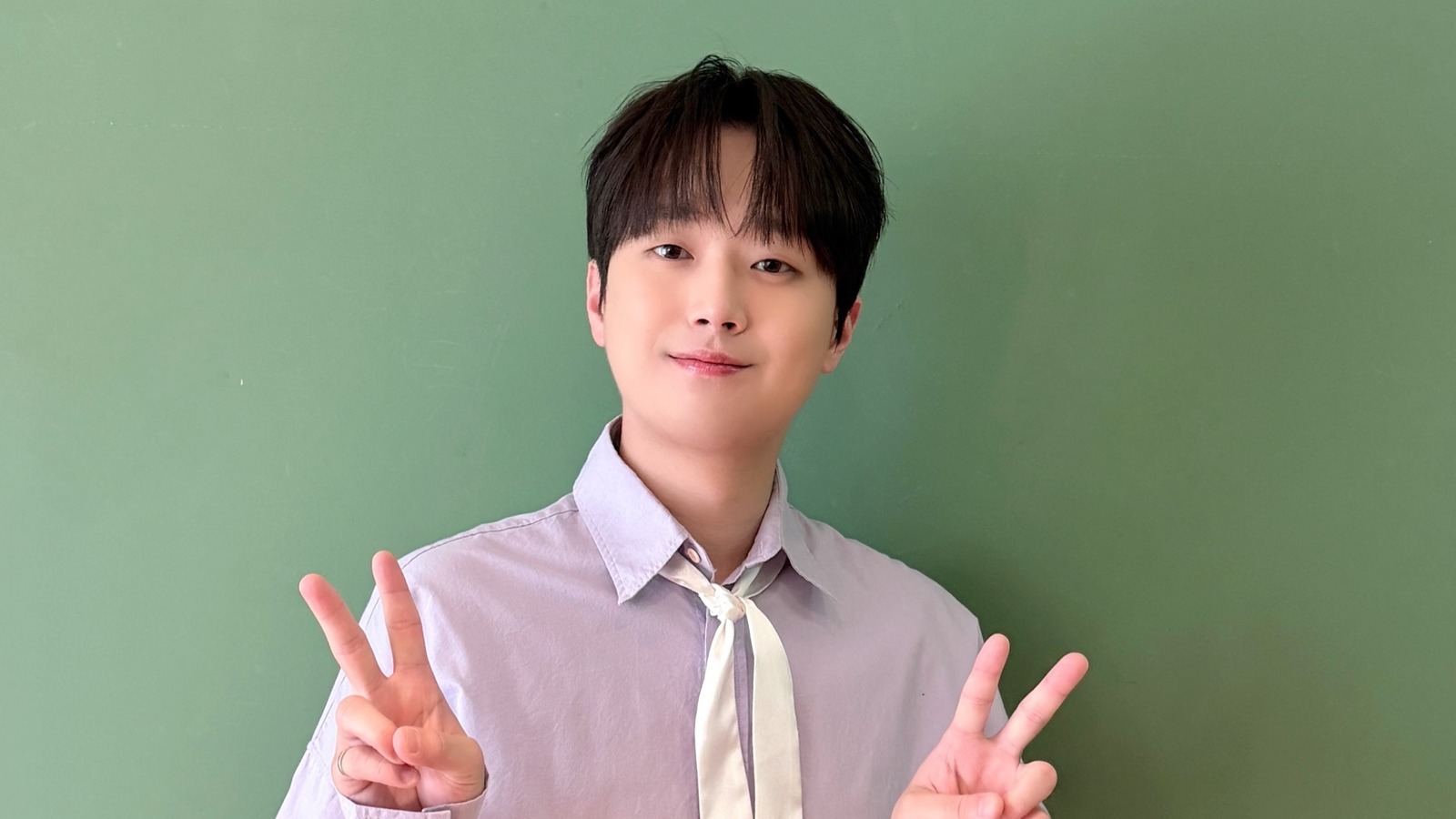 연보라 셔츠에 흰 스카프를 매고 두 손으로 브이를 하며 웃는 이찬원