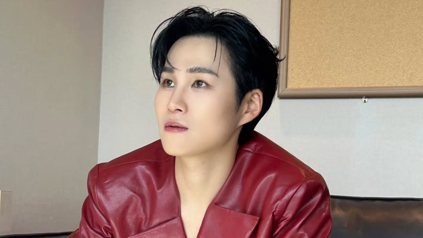 붉은 가죽 재킷을 입고 옆쪽을 바라보는 김희재